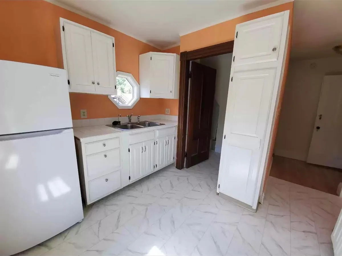 Before: the old galley kitchen with orange walls and dated cabinets