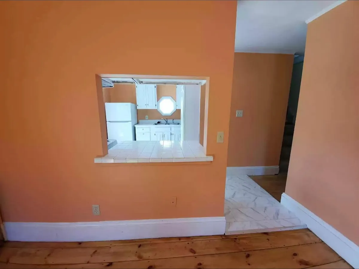 Before: the living room wall, with a small pass-through into the old kitchen